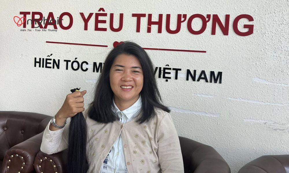 Cô gái cầm bó tóc sau khi hiến tóc ở Gia Lai trong tiệm tóc