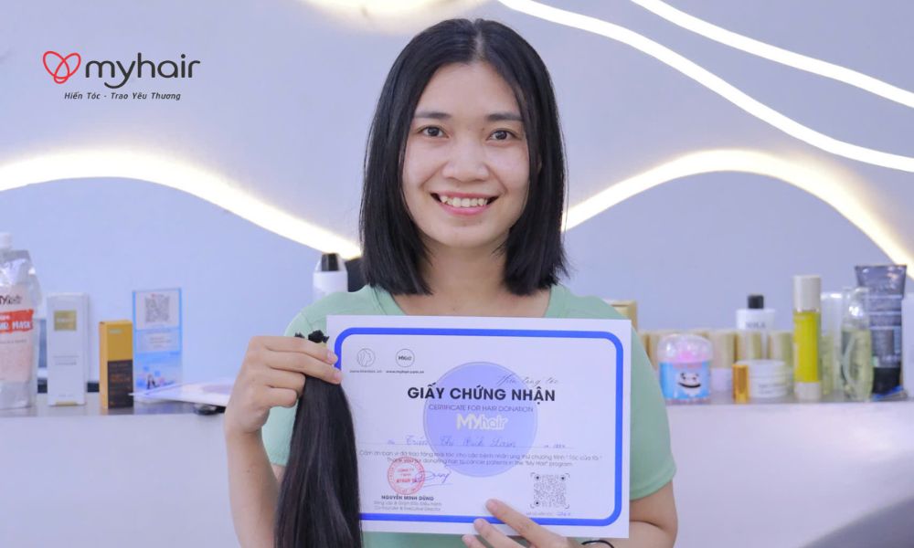 Cô gái cầm mái tóc vừa cắt sau khi hiến tóc ở Bạc Liêu